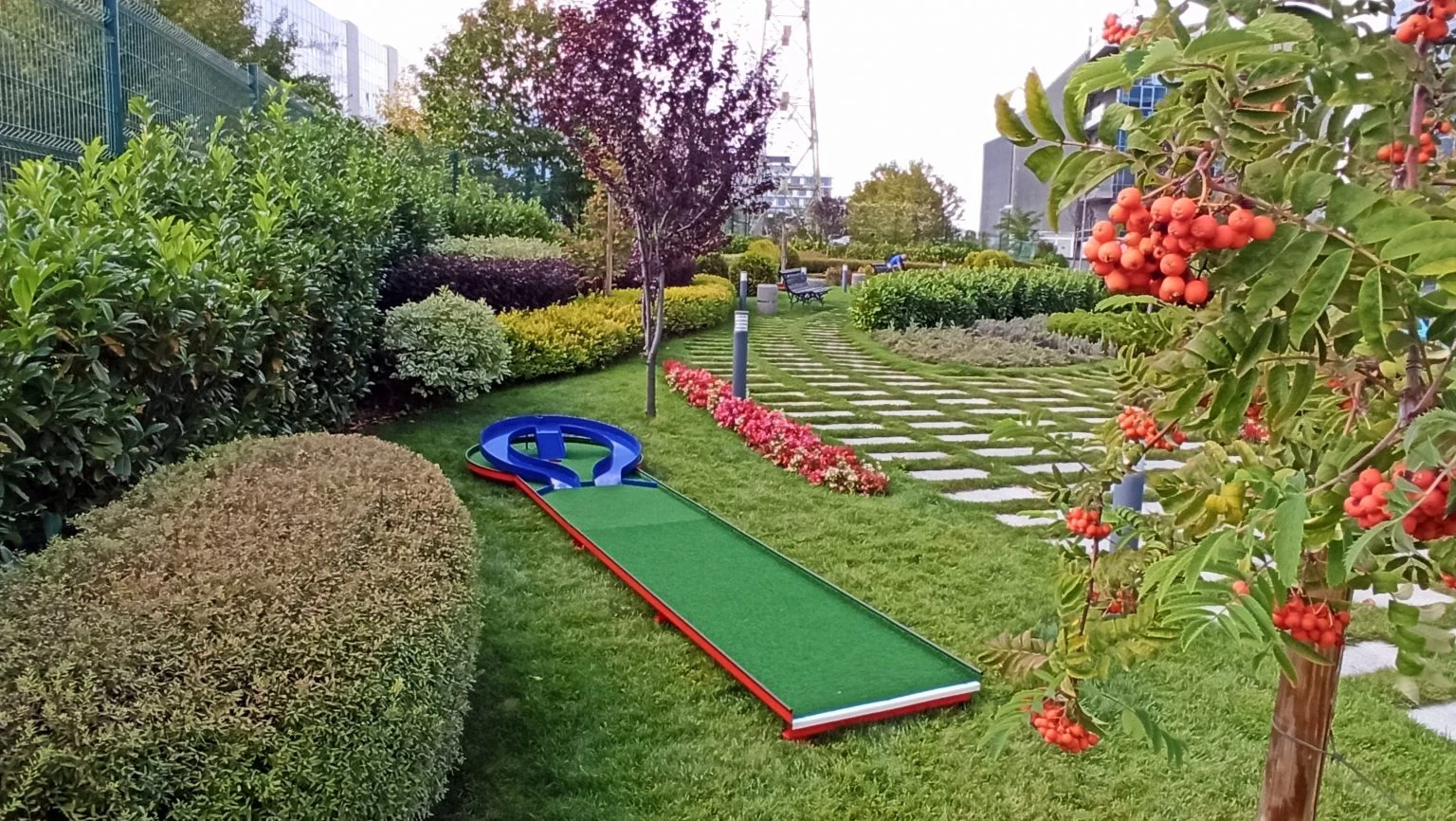 Outdoor miniature golf lane surrounded by landscaped gardens